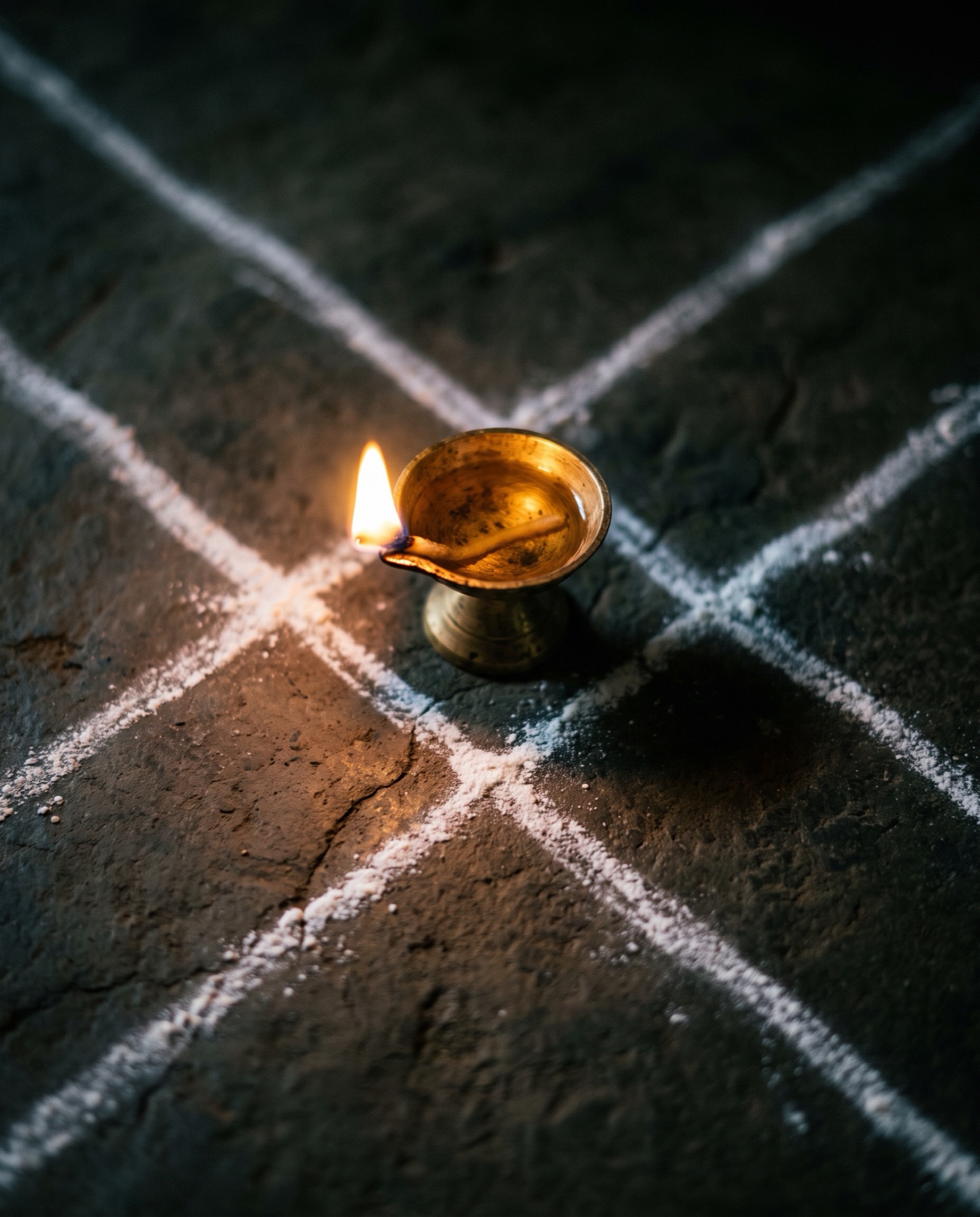 A brass diya at the center of a drawn grid